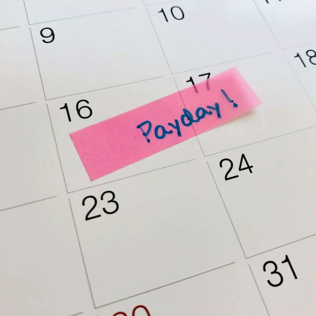 stop living paycheck to paycheck no savings, payday to payday with no savings. image of calendar with payday written on date.