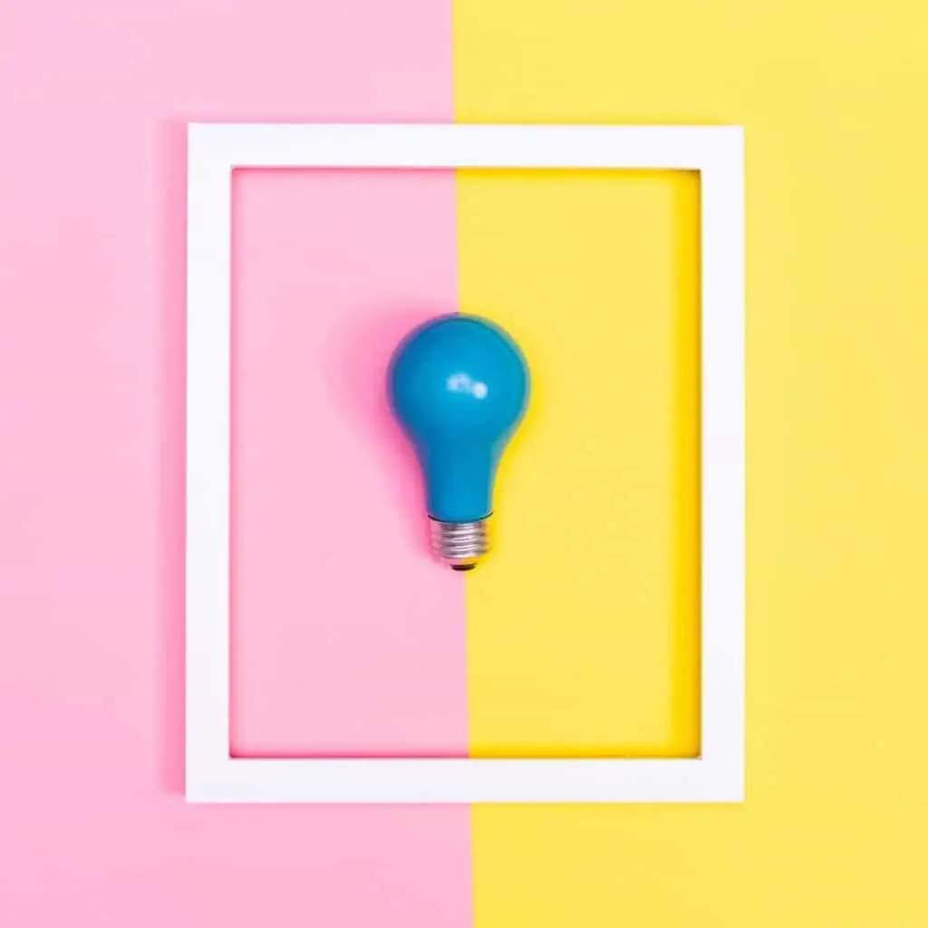 image of a blue lightbulb on color blocked (pink and yellow) background depicting clear vision for business plan