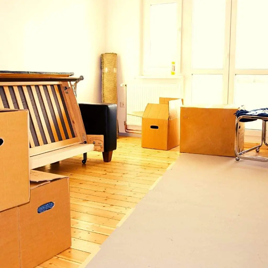 image; bedframe and packed cardboard moving boxes